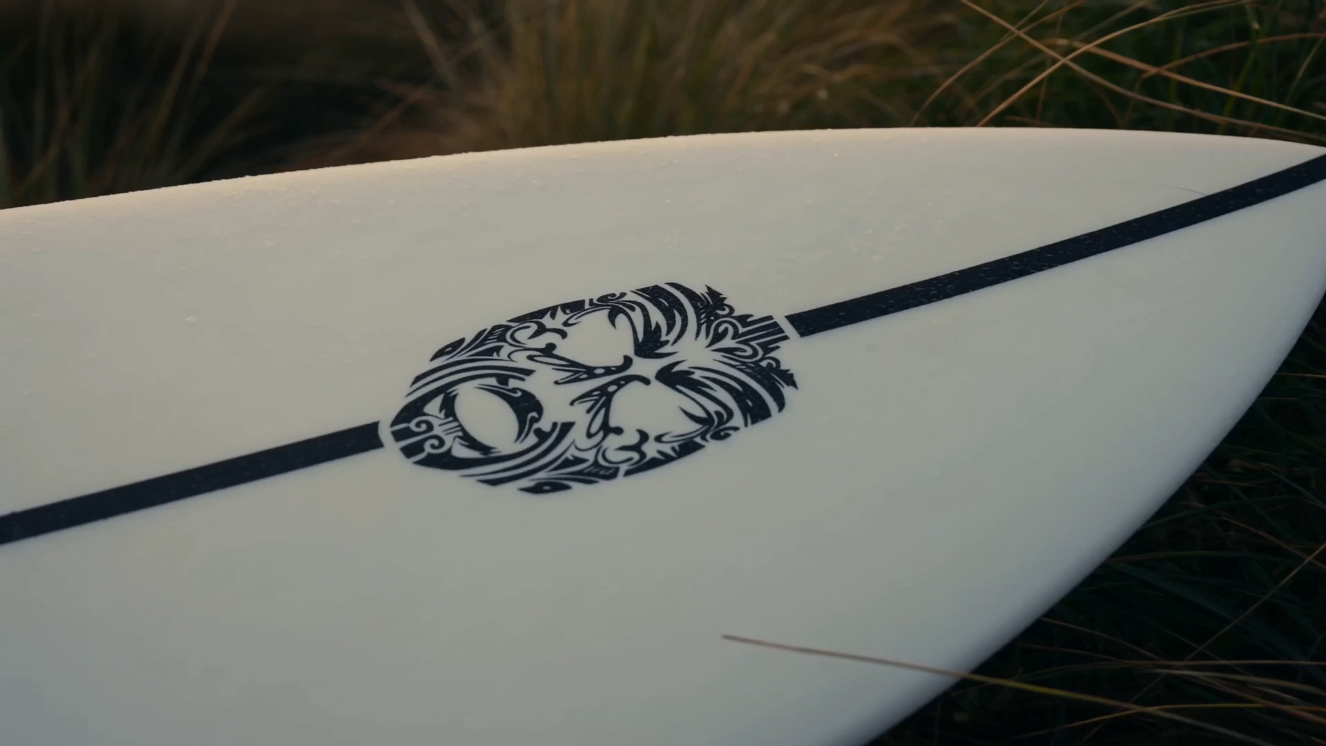 Surfboard with Kanohi Māori-inspired face symbol